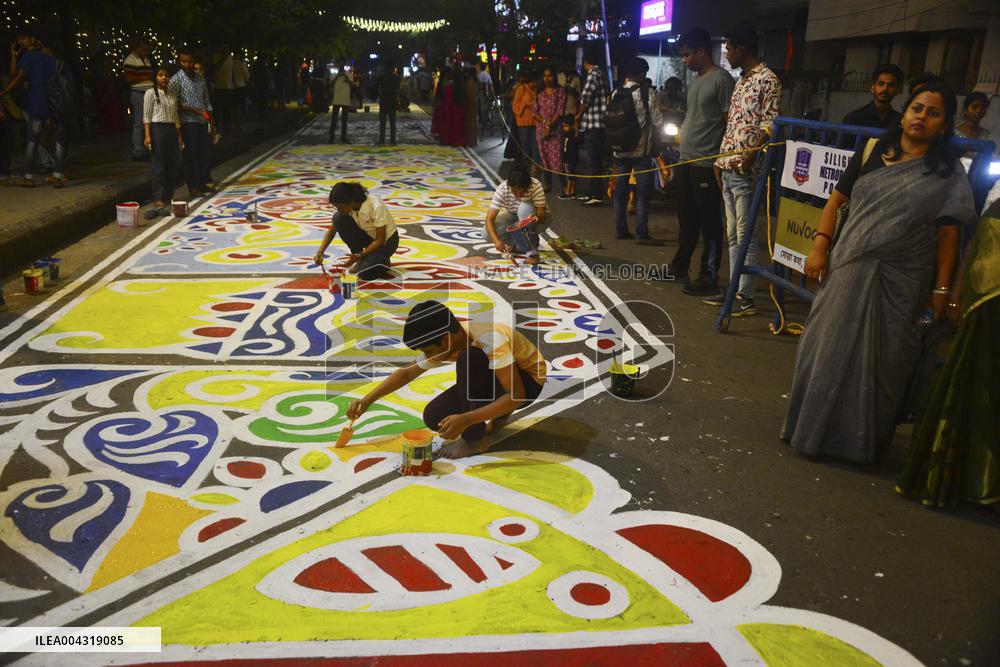 Youths paint designs on the road to celebrate Bengali New Year