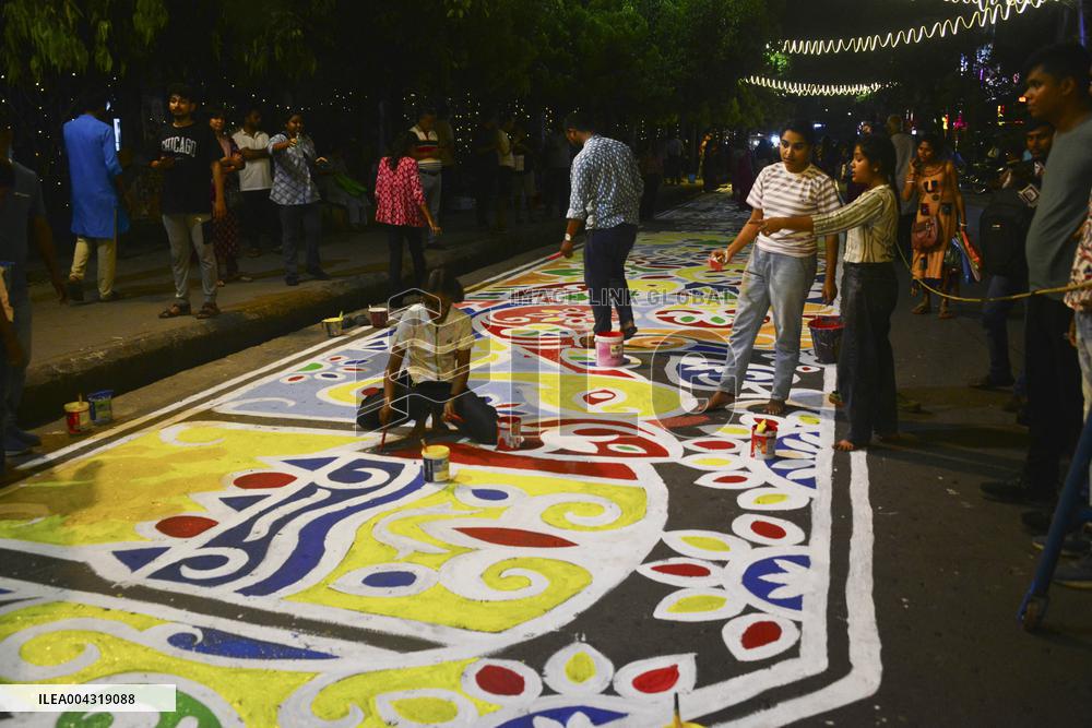 Youths paint designs on the road to celebrate Bengali New Year