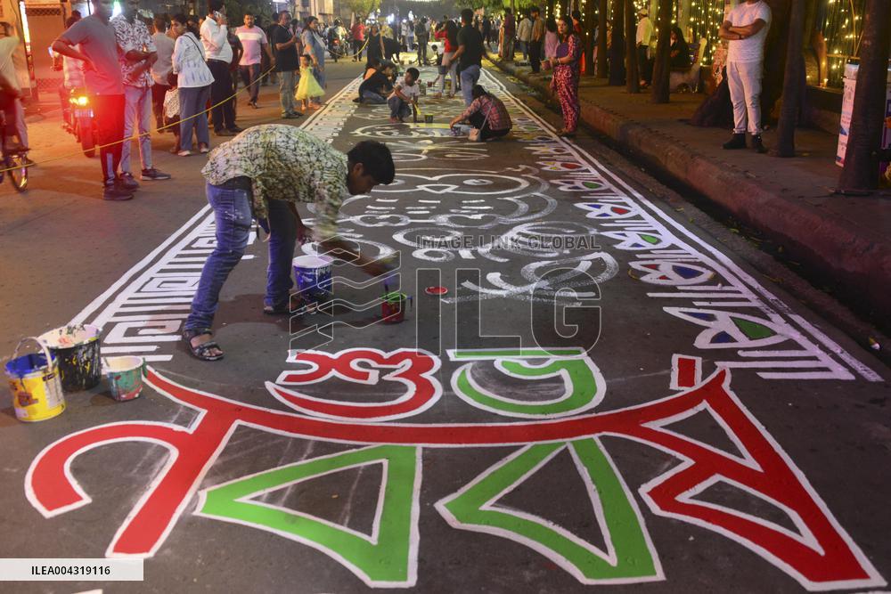 Youths paint designs on the road to celebrate Bengali New Year