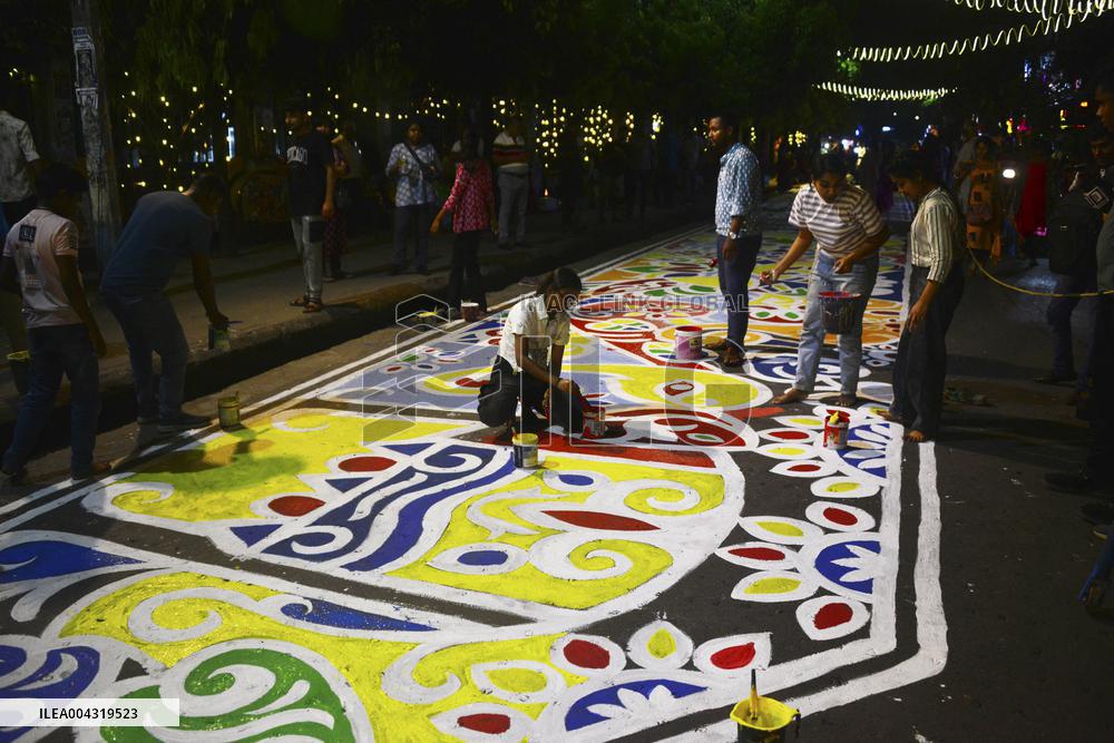 Youths paint designs on the road to celebrate Bengali New Year