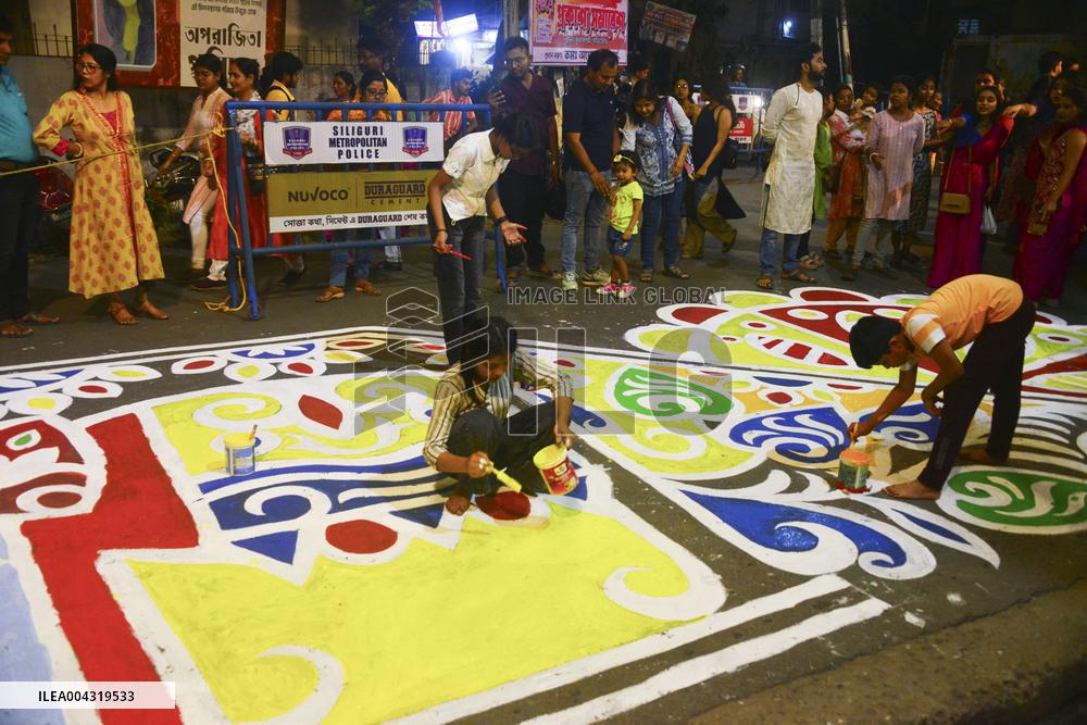 Youths paint designs on the road to celebrate Bengali New Year