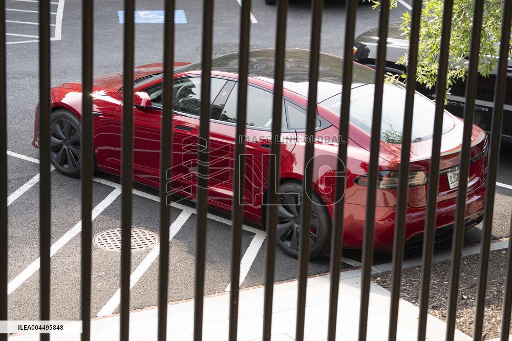 A red Tesla is parked on West Executive Drive