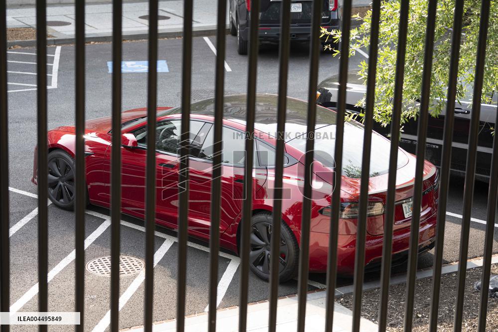 A red Tesla is parked on West Executive Drive
