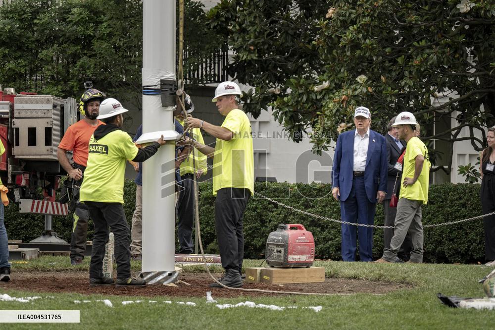 President Trump speaks to the press while workers install a new flag pole on South Lawn