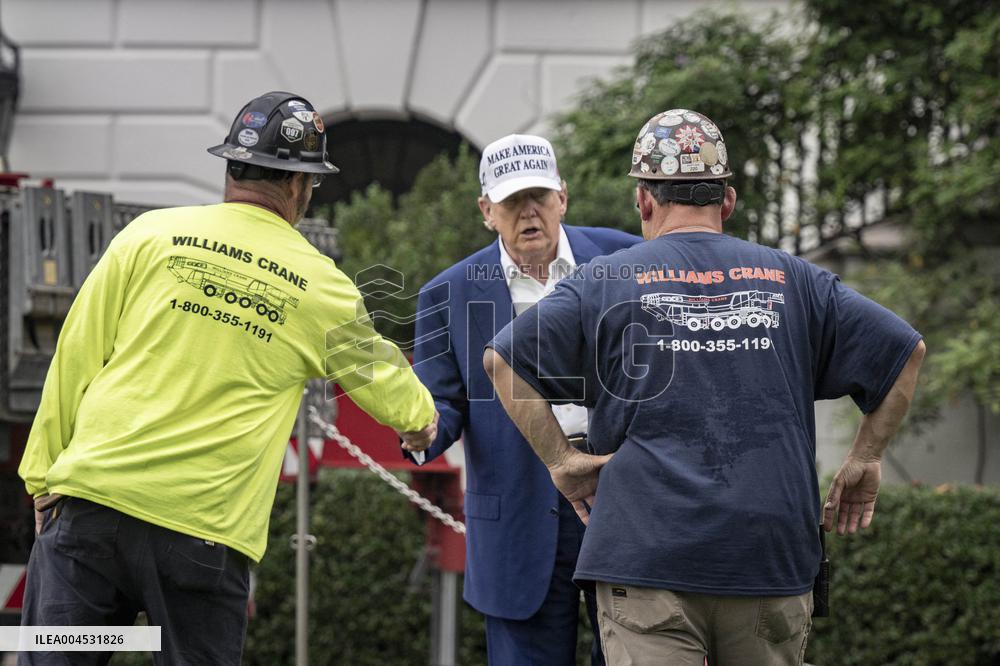 President Trump speaks to the press while workers install a new flag pole on South Lawn