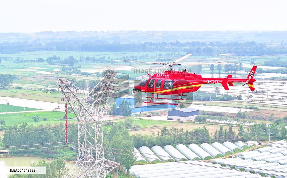 Helicopters Conduct Aerial Patrols on Ultra-high Voltage Transmission Lines