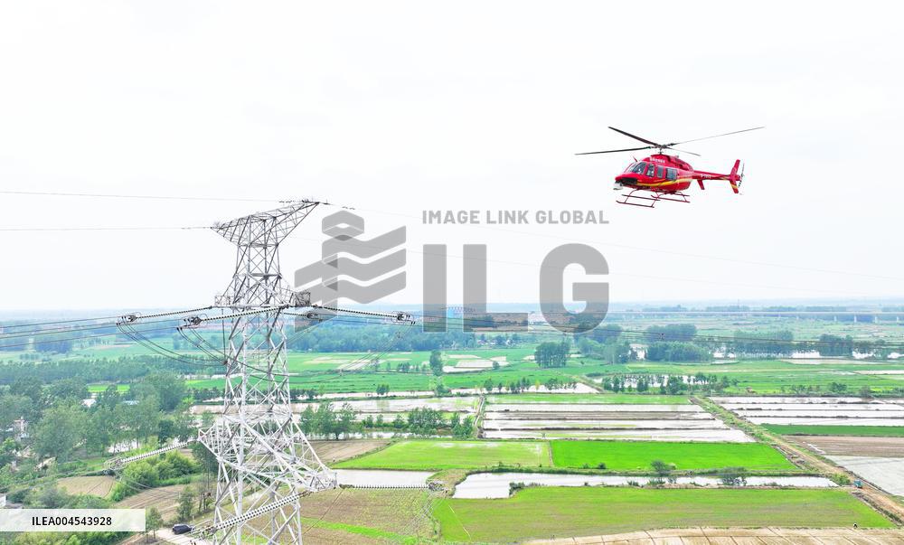 Helicopters Conduct Aerial Patrols on Ultra-high Voltage Transmission Lines