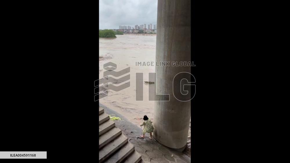 China: Woman Rescues Dog Swept Away by Floodwaters in Hunan