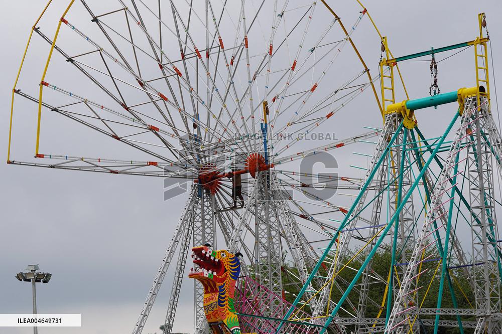 A Labourer Works on A Giant Ferris Wheel - India
