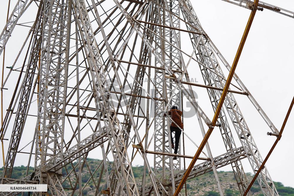 A Labourer Works on A Giant Ferris Wheel - India