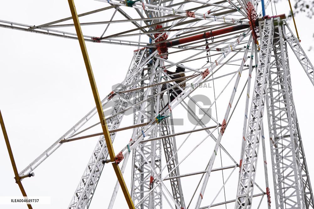 A Labourer Works on A Giant Ferris Wheel - India