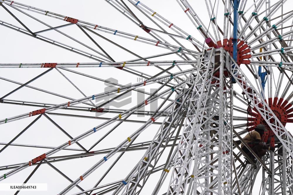A Labourer Works on A Giant Ferris Wheel - India