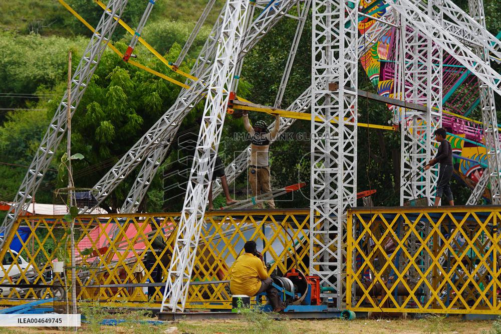 A Labourer Works on A Giant Ferris Wheel - India