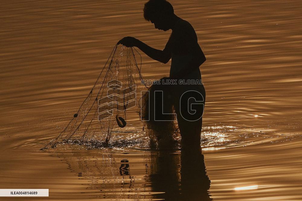 A Man Fishes in The Shallow Waters - India