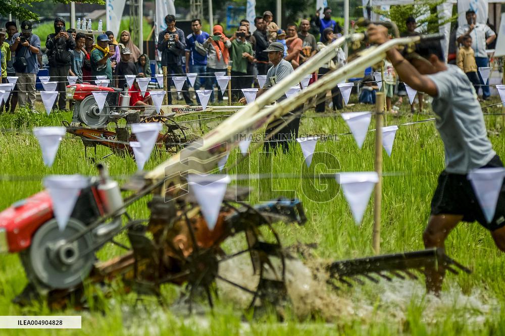 Farmers in a rice field tractors racing on a muddy rice field - Kebonagung