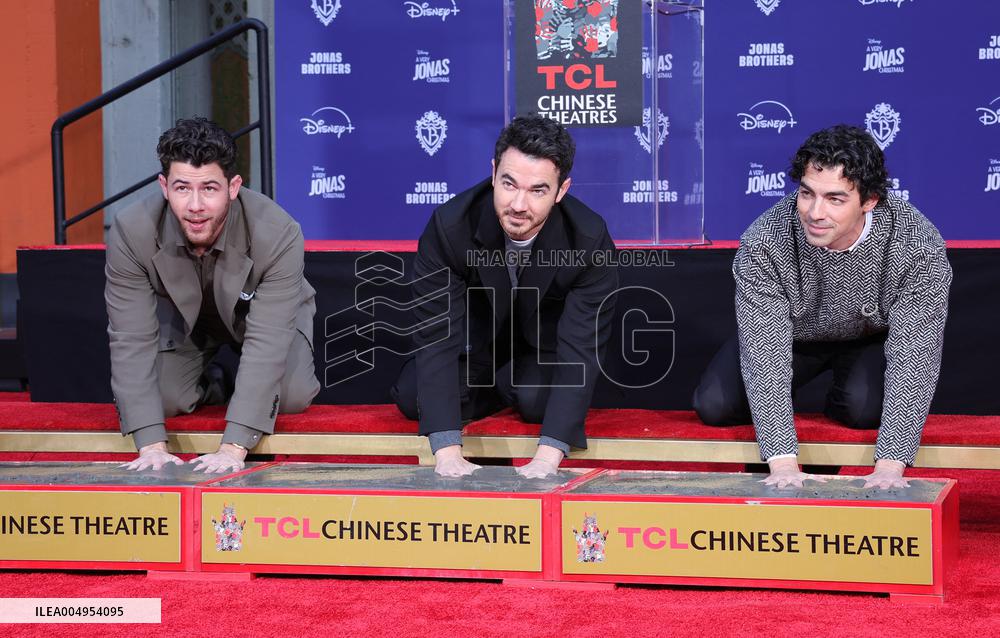 Jonas Brothers Hand And Footprint In Cement Ceremony - LA