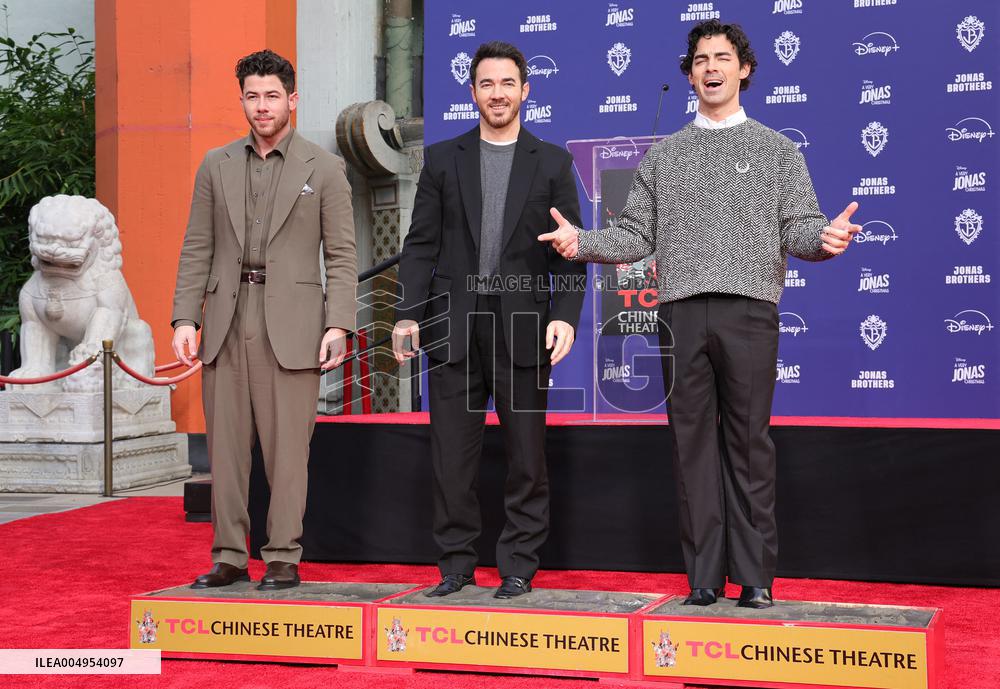 Jonas Brothers Hand And Footprint In Cement Ceremony - LA