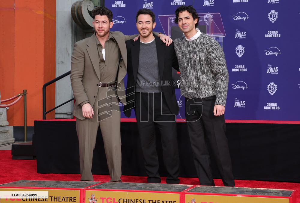 Jonas Brothers Hand And Footprint In Cement Ceremony - LA