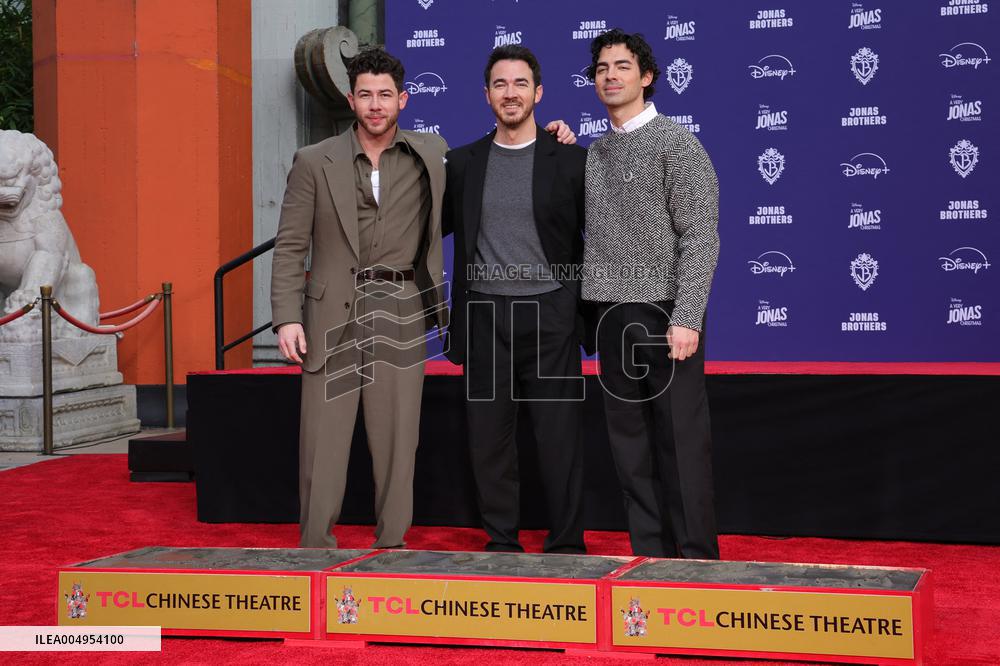 Jonas Brothers Hand And Footprint In Cement Ceremony - LA