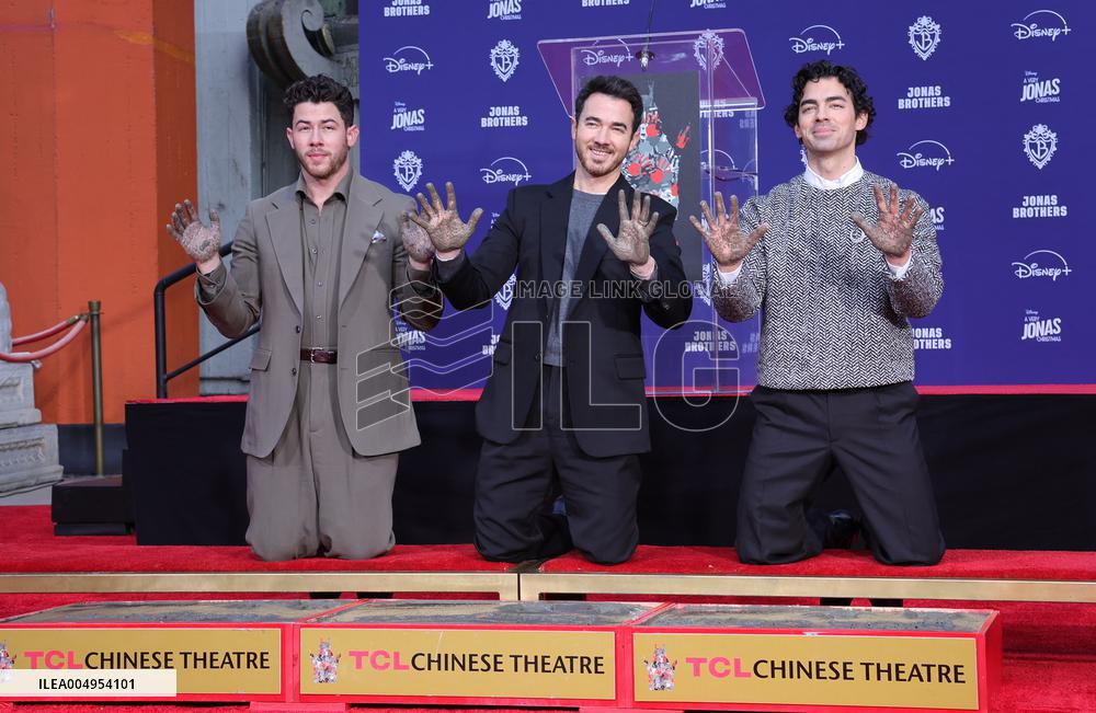 Jonas Brothers Hand And Footprint In Cement Ceremony - LA