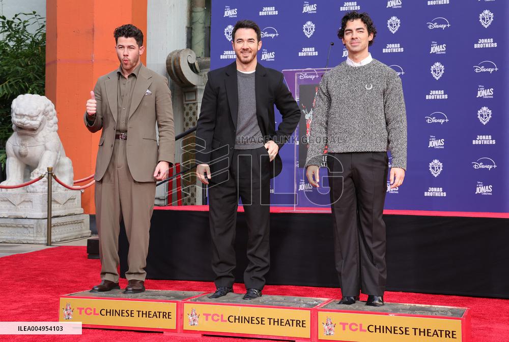 Jonas Brothers Hand And Footprint In Cement Ceremony - LA