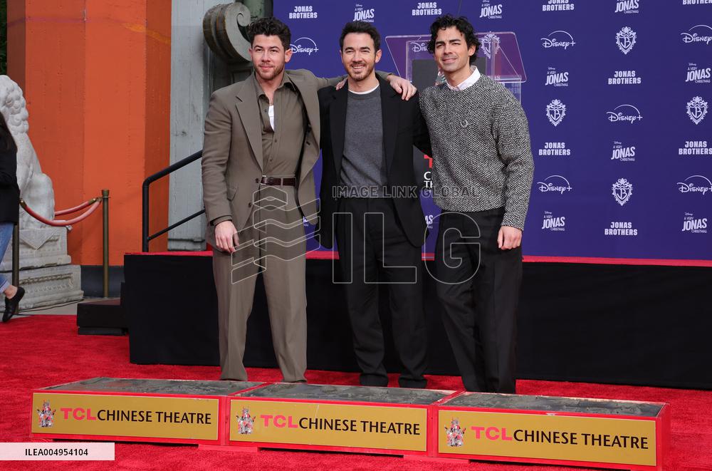 Jonas Brothers Hand And Footprint In Cement Ceremony - LA