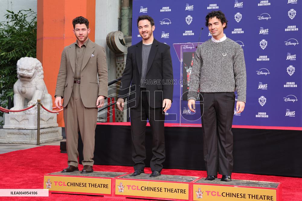 Jonas Brothers Hand And Footprint In Cement Ceremony - LA