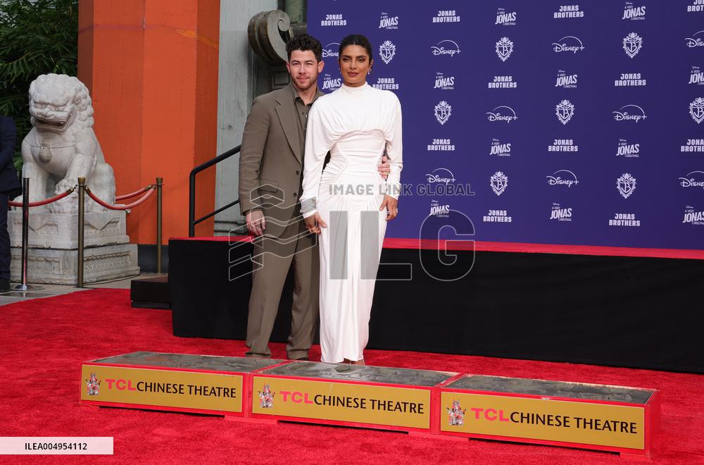 Jonas Brothers Hand And Footprint In Cement Ceremony - LA