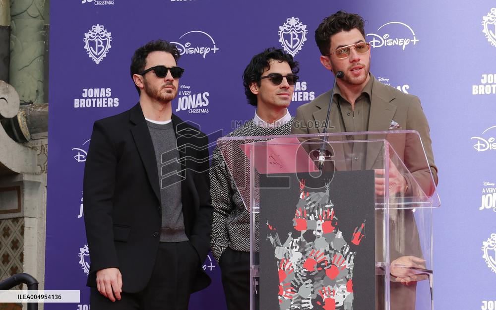 Jonas Brothers Hand And Footprint In Cement Ceremony - LA