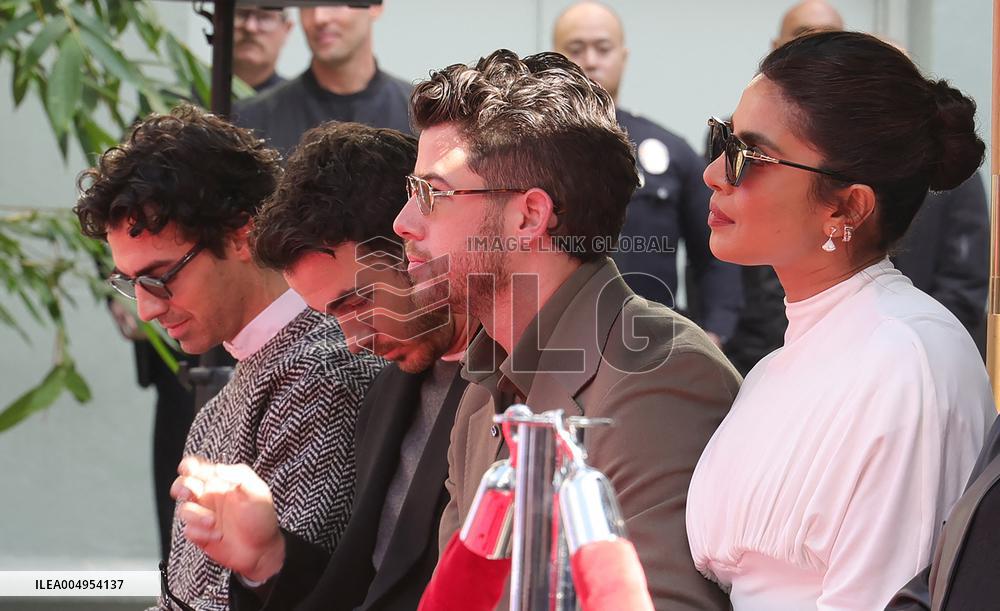 Jonas Brothers Hand And Footprint In Cement Ceremony - LA