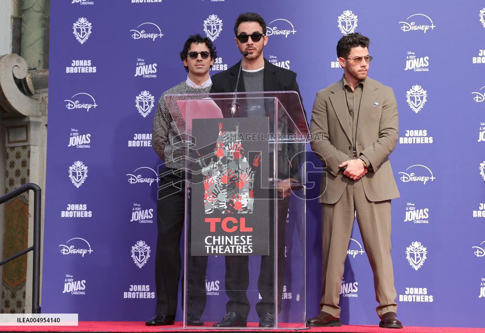 Jonas Brothers Hand And Footprint In Cement Ceremony - LA
