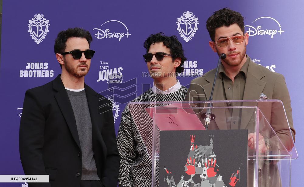 Jonas Brothers Hand And Footprint In Cement Ceremony - LA