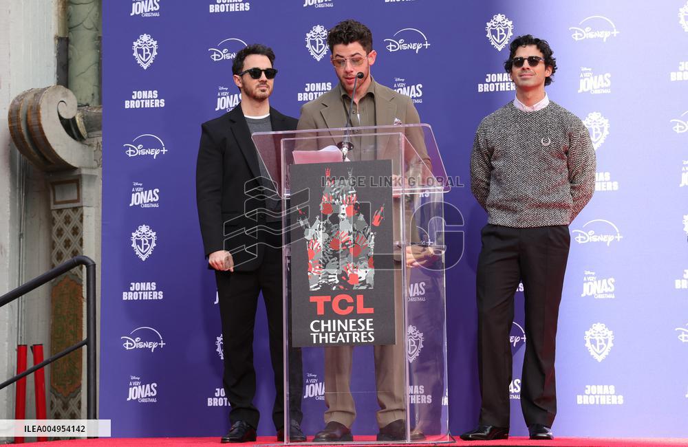 Jonas Brothers Hand And Footprint In Cement Ceremony - LA