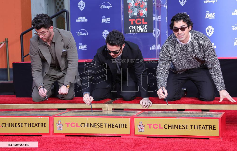 Jonas Brothers Hand And Footprint In Cement Ceremony - LA