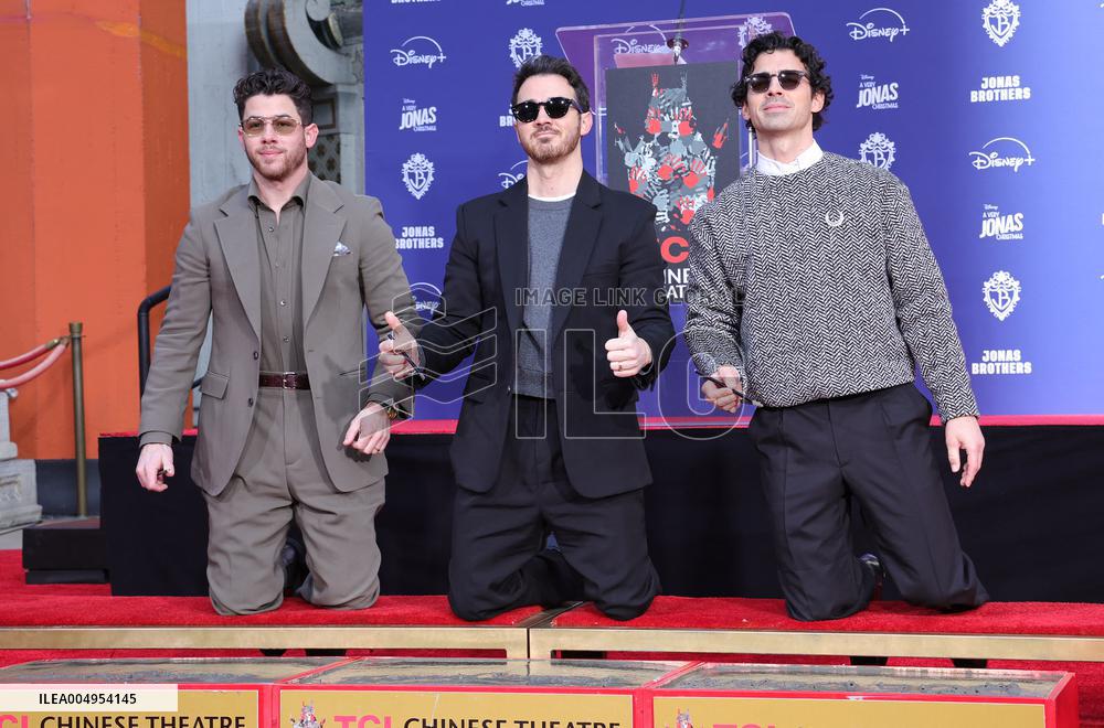 Jonas Brothers Hand And Footprint In Cement Ceremony - LA