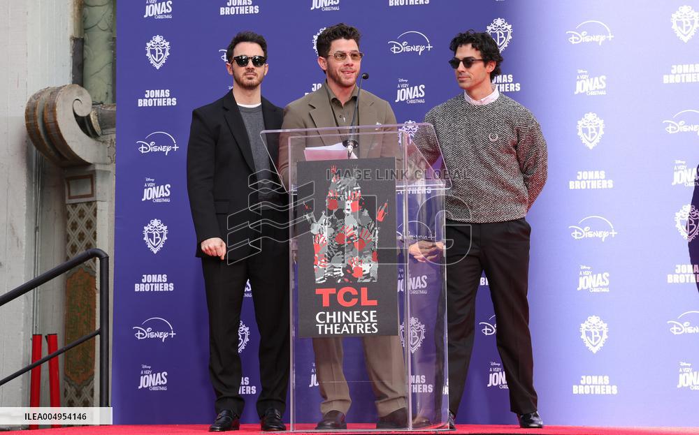 Jonas Brothers Hand And Footprint In Cement Ceremony - LA