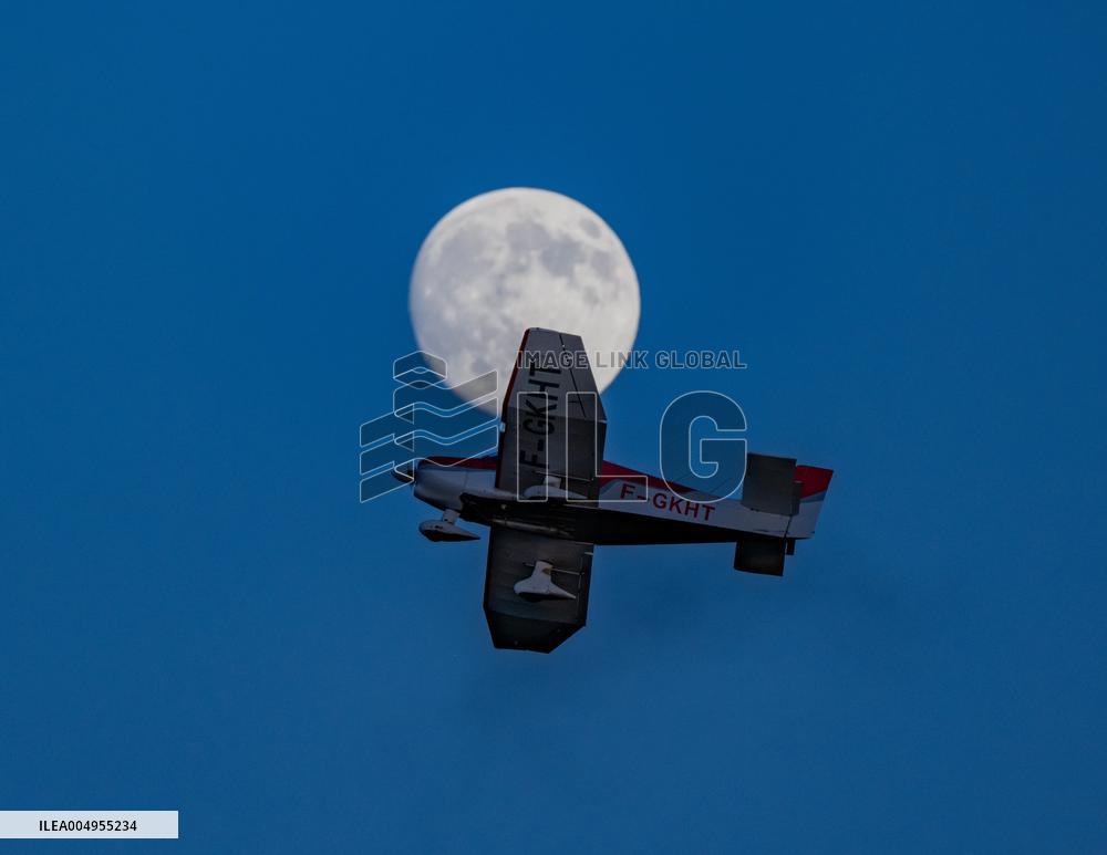 Flying Club Plane Passes Full Moon