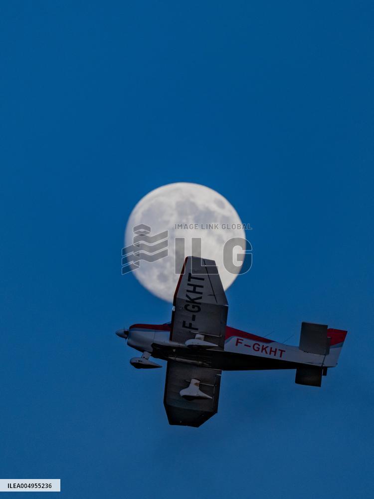 Flying Club Plane Passes Full Moon