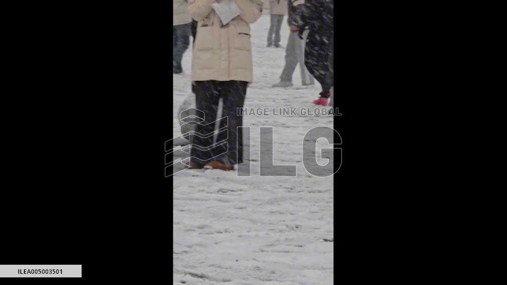 China: Playful Dog Chases Soccer Ball in Snowy College Campus
