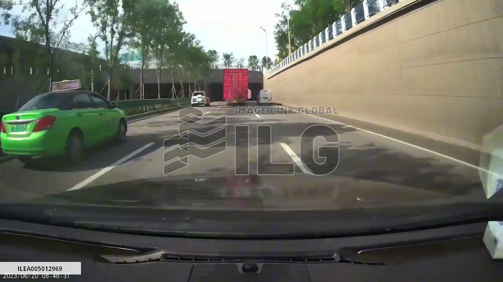 China: Driver Narrowly Avoids Crash as Truck Container Tips Over