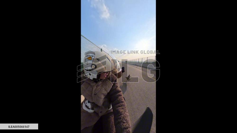 China: Goose Flies Alongside Motorcycle on Highway