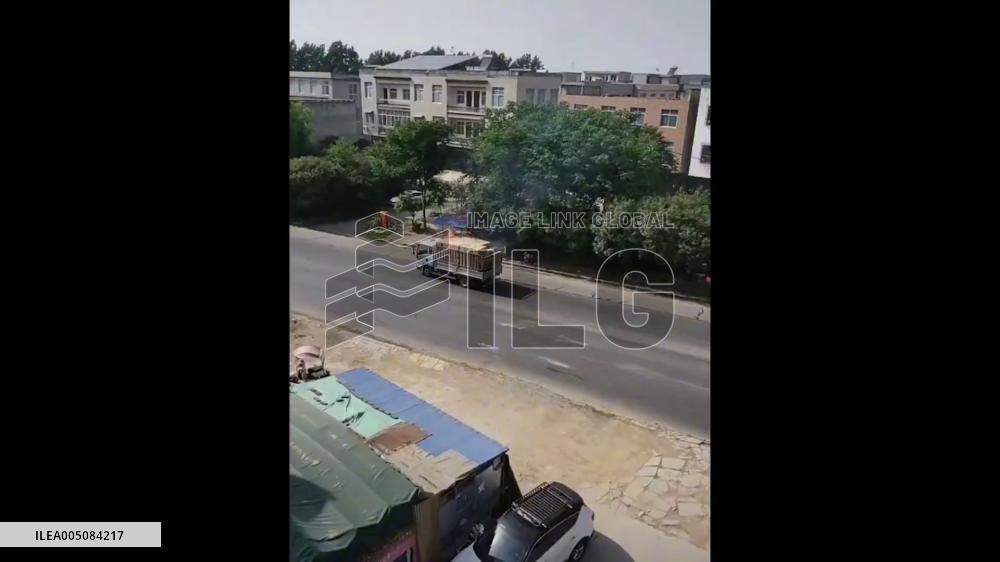 China: Passing Water Sprinkler Truck Helps Extinguish Burning Cargo Truck in Hubei