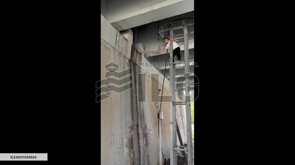 China: Man Rescues Stranded Kitten Using Long Wooden Board in Hubei