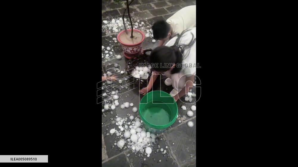 China: Mother and Son Collect Basket of Giant Hailstones in Hebei