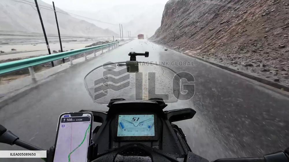 China: Motorcyclist Rides Through Falling Rocks on Highway in Xinjiang